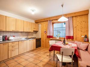 uma cozinha e sala de jantar com mesa e cadeiras em Ciasa Lino Rotic em Pozza di Fassa