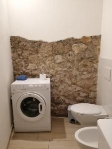 a bathroom with a washing machine and a toilet at Per Due in Porto Santo Stefano +7 photos