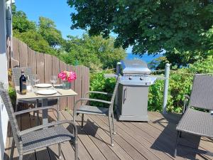 einen Grill auf einer Terrasse mit einem Tisch und Stühlen in der Unterkunft Apartment Feodora in Sassnitz