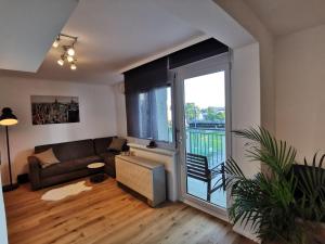 uma sala de estar com um sofá e uma grande janela em Citycenter Apartment Stadthalle em Graz