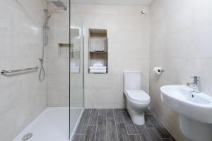 
a bathroom with a toilet, sink, and shower at Killarney Dromhall Hotel in Killarney
