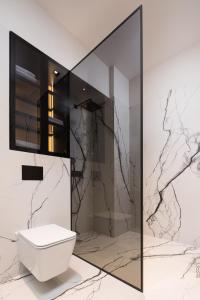 a bathroom with a white toilet and marble walls at Plaza Apartments in Opatija