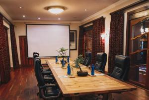 a conference room with a table and chairs and a screen at Kleinkaap Boutique Hotel in Centurion +45 photos