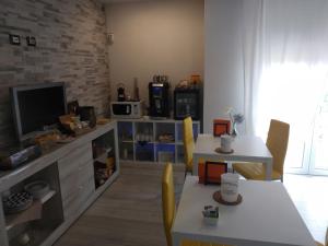 a living room with a television and a table and chairs at B&B CELESTE in Bedonia