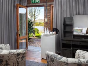 a living room with chairs and a refrigerator and a door at Waschbank River Lodge in Gariepdam