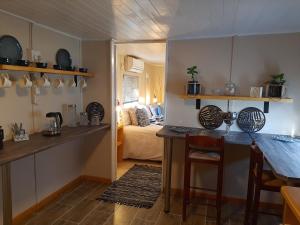 uma cozinha com uma mesa e um quarto com uma cama em Rosenhof Nut Hut - Tented Cabin under the Pecans em Clanwilliam