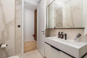 a bathroom with a white sink and a mirror at Plaza Apartments in Opatija