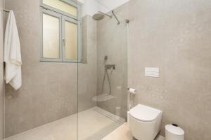 a bathroom with a toilet and a glass shower at Plaza Apartments in Opatija