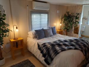 um quarto com uma cama, 2 candeeiros e uma janela em Rosenhof Nut Hut - Tented Cabin under the Pecans em Clanwilliam