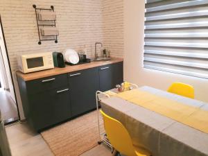une cuisine avec une table et un four micro-ondes sur un comptoir dans l'établissement Eva Home, à Roşiori de Vede