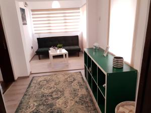 - un salon avec un meuble vert et un canapé dans l'établissement Eva Home, à Roşiori de Vede