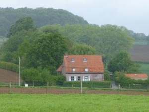 une maison avec un toit rouge dans un champ dans l'établissement B&B Haere Mai, à Loker