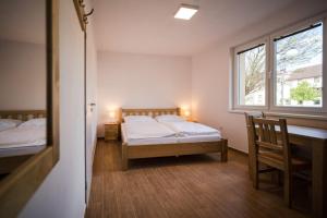 sypialnia z 2 łóżkami, biurkiem i oknem w obiekcie Apartmány pod Pajrekem w mieście Nýrsko +6 zdjęć