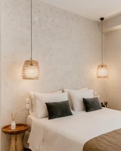 two beds in a bedroom with two lamps and a table at Bohèmian Boutique Hotel Lefkada in Lefkada