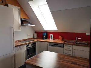 a kitchen with white cabinets and a large skylight at Ferienwohnung Irslenbach in Altoberndorf