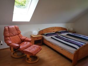 a bedroom with a bed and a chair and a window at Ferienwohnung Irslenbach in Altoberndorf