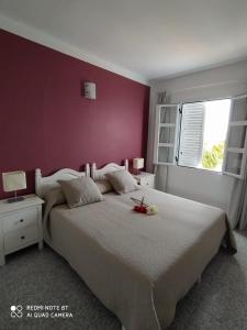 a bedroom with a large bed with a purple wall at Casitas La Condesa in Valle Gran Rey