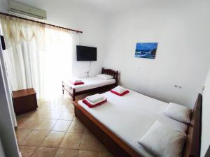 a bedroom with two twin beds and a television at Apartments Himara Premium in Himare