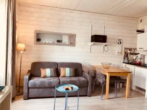 a living room with a couch and a table at studio Newport à 50 m du Marché et calme in Le Touquet-Paris-Plage