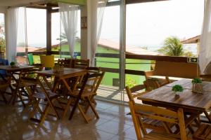 a restaurant with tables and chairs and a balcony at Pousada Brisa da Canoa in Canoa Quebrada