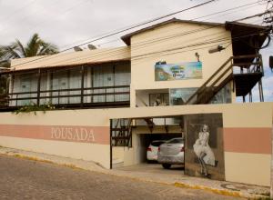 a building with a car parked in a garage at Pousada Brisa da Canoa in Canoa Quebrada