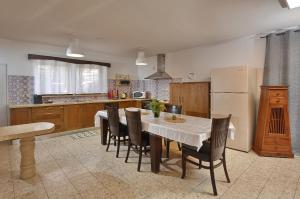 a kitchen with a table with chairs and a refrigerator at וילה גאיה בכנרת-VIILA GAYA in Migdal