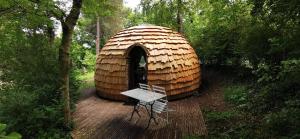 a yurt with a bench in the middle of a forest at camping de la chagnée in Saint-Aubin-le-Cloud