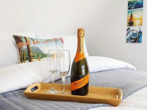 a bottle of wine and two glasses on a bed at Viva Guest House in Clacton-on-Sea