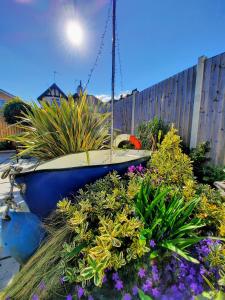 un barco sentado en un jardín con flores en Viva Guest House, en Clacton-on-Sea