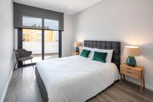 een slaapkamer met een groot wit bed met groene kussens bij Apartment Confort 404 in Portimão