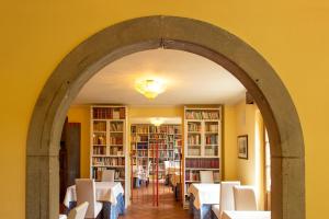 łuk w jadalni ze stołami i krzesłami w obiekcie Borgo I Tre Baroni - Spa Suites & Resort w mieście Poppi