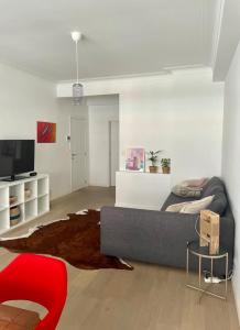 a living room with a couch and a red chair at Appartement op top locatie in Antwerpen in Antwerp