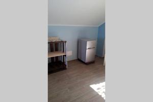 a kitchen with a refrigerator and a wooden floor at Mansarda a Noli in Noli