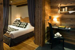 um quarto com uma cama e uma secretária com um chapéu numa cadeira em Chalet-Hôtel Hermitage em Chamonix-Mont-Blanc