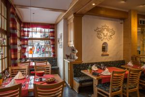 a restaurant with wooden tables and chairs and a window at Ferienwohnung Hirschen in Grindelwald