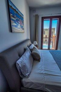 een slaapkamer met een bank met kussens en een raam bij Fort Chambray Harbor Breeze in Għajnsielem