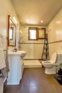een badkamer met een toilet, een wastafel en een spiegel bij Fort Chambray Harbor Breeze in Għajnsielem
