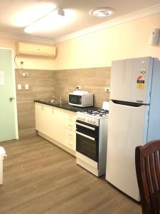 a kitchen with a white refrigerator and a microwave at Bay Lodge in Denham