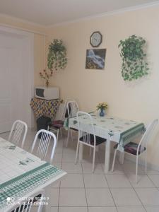 a dining room with a table and chairs and a clock at Akác Vendégház in Eger +22 photos