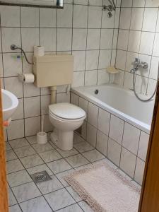 a bathroom with a toilet and a tub and a sink at APARTMAN ADRIANA in Podaca