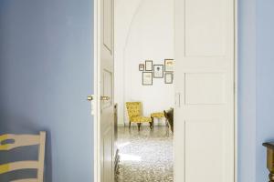 a hallway with a door open to a room with chairs at Palazzo Dante B&B Racale in Racale