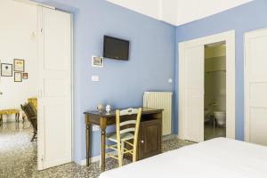 a bedroom with blue walls and a desk and a bed at Palazzo Dante B&B Racale in Racale