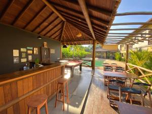 Pousada Villa Dos Sonhos في إيتاكاري: بار في الهواء الطلق مع طاولات وكراسي خشبية