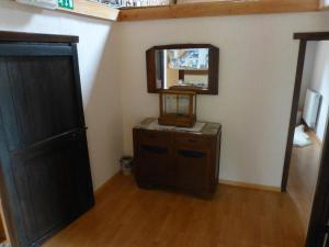 a room with a mirror and a dresser and a door at B&B Haere Mai in Loker