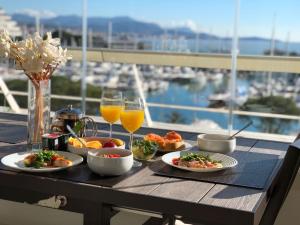 einen Tisch mit Teller mit Lebensmitteln und Gläsern Orangensaft in der Unterkunft Apartments at Commodoro in Villeneuve-Loubet