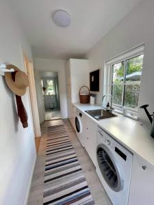 een keuken met een wastafel en een wasmachine bij Sommerhus Mossø in Skanderborg