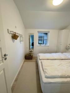 a bedroom with two beds and a window at Sommerhus Mossø in Skanderborg