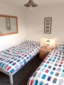 a bedroom with two beds and a table with a lamp at Wayside in Fulmodeston