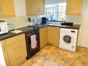 een keuken met een wasmachine en een vaatwasser bij Wayside in Fulmodeston