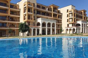 a large swimming pool in front of a building at Golf Villa in Lighthouse Golf & SPA Resort in Balchik